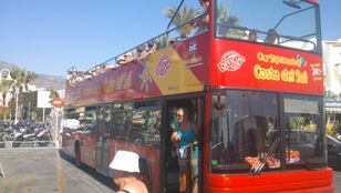 Curious tourist stepping off the city sightseeing bus, eager to explore the wonders of Benalmadena's attractions and culture.